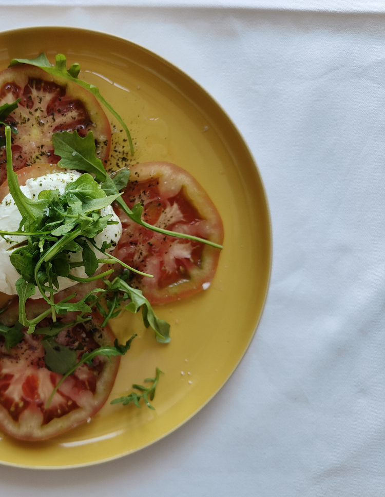 Detail of a salad of tomato, cheese and rocket.